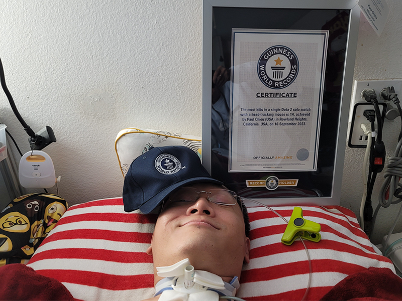 Paul next to a Guinness World Record certificate he got for breaking a Dota 2 record using a head-tracking mouse.